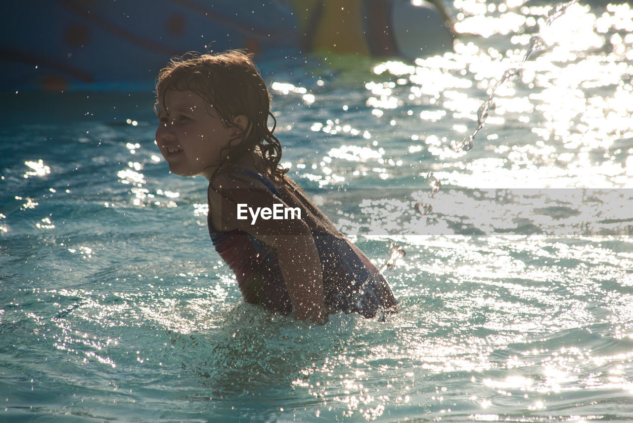 Side view of girl enjoying in swimming pool
