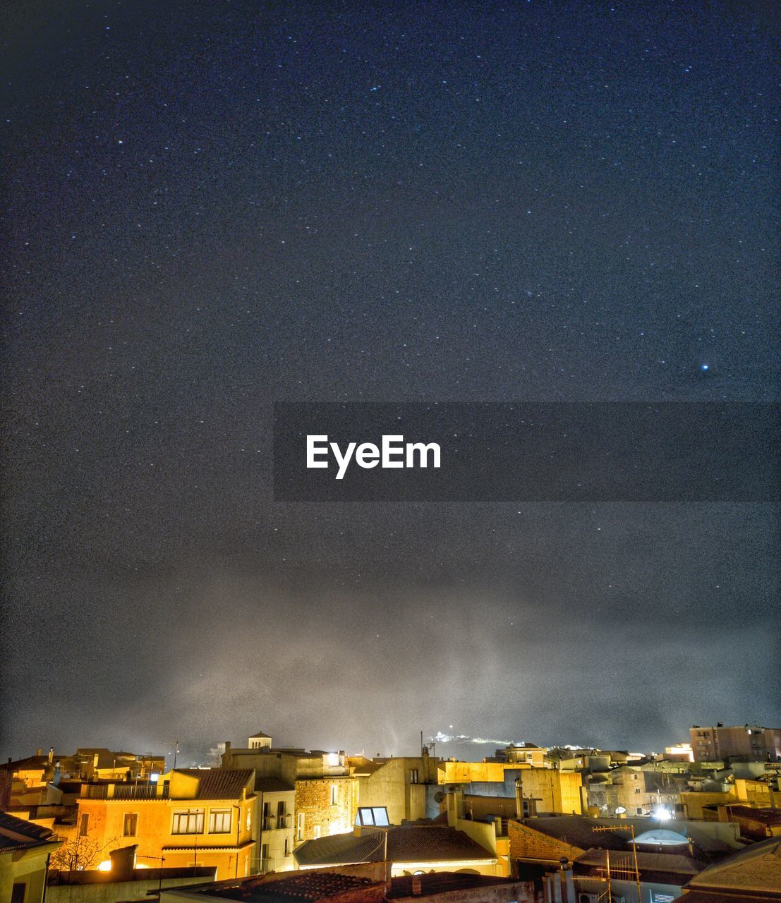 Illuminated buildings against sky at night