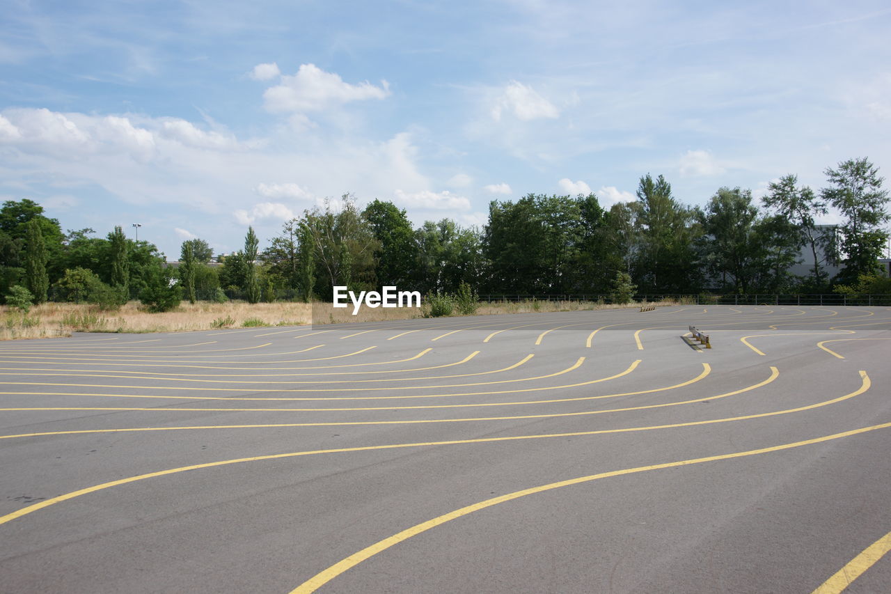 EMPTY ROAD WITH TREES IN BACKGROUND