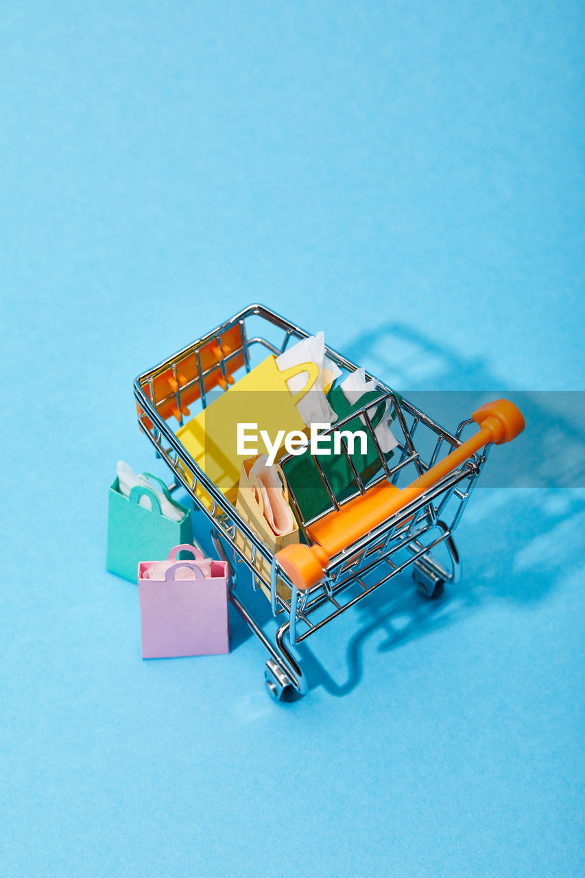 High angle view of shopping cart on blue background