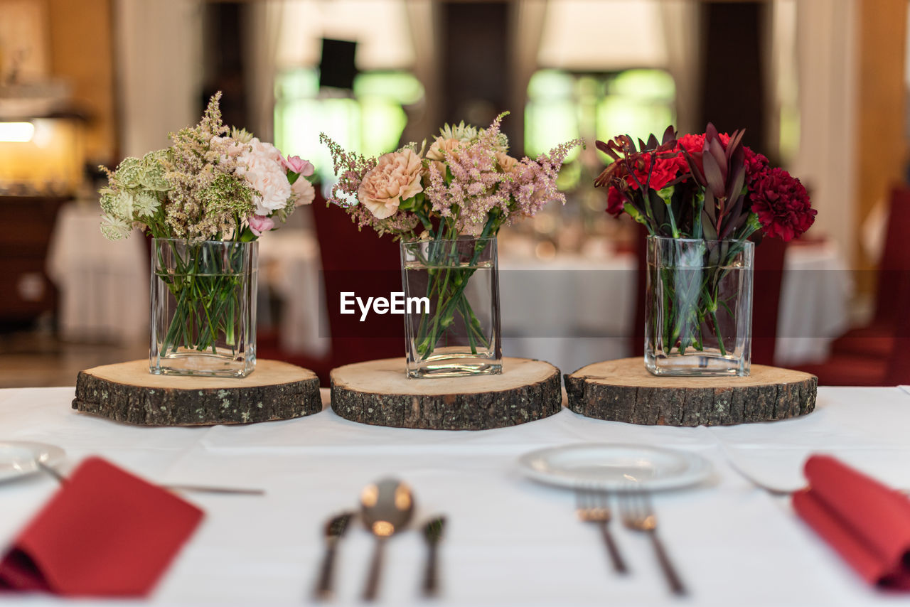Pre wedding ceremony flower bouquets on wooden plates as a main table decoration