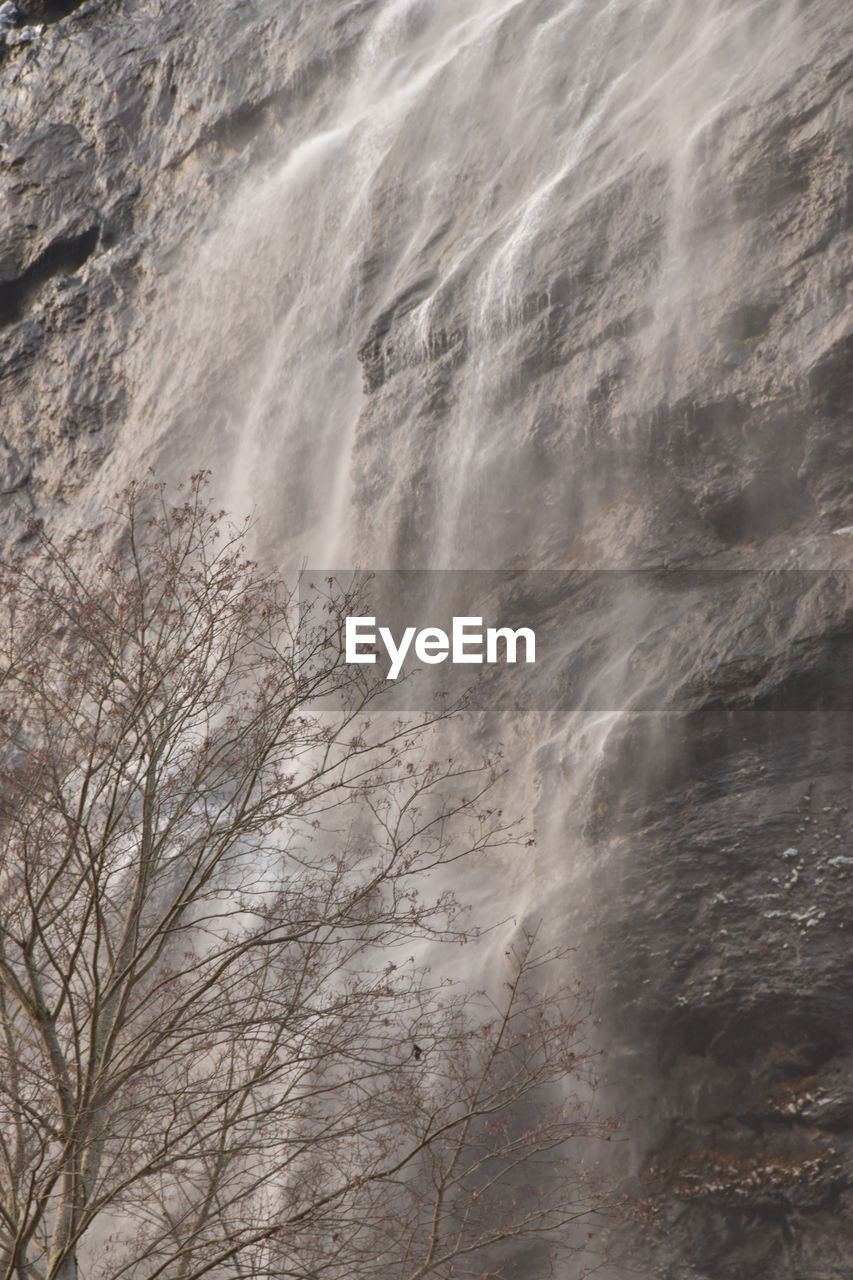 FULL FRAME SHOT OF WATER FLOWING ON ROCKS