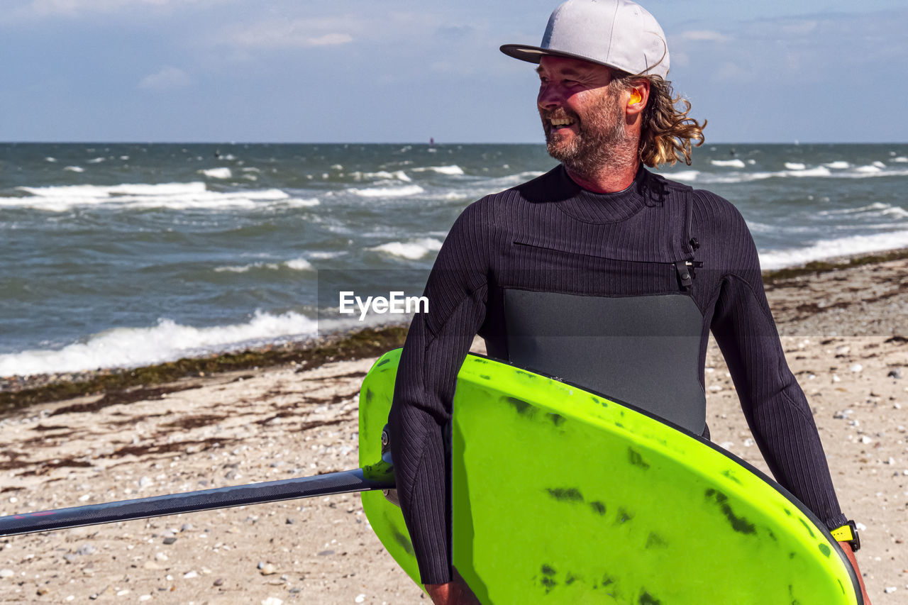 rear view of man with surfboard at beach