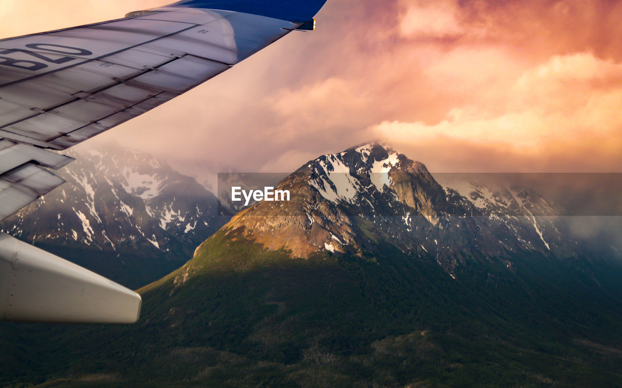 Scenic view of mountains against cloudy sky during sunset