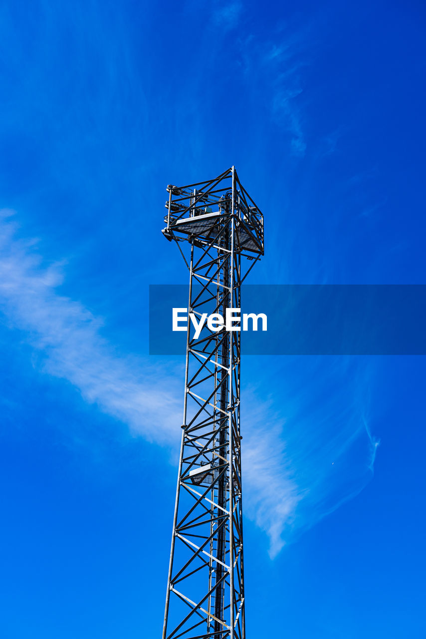 Low angle view of communications tower against blue sky