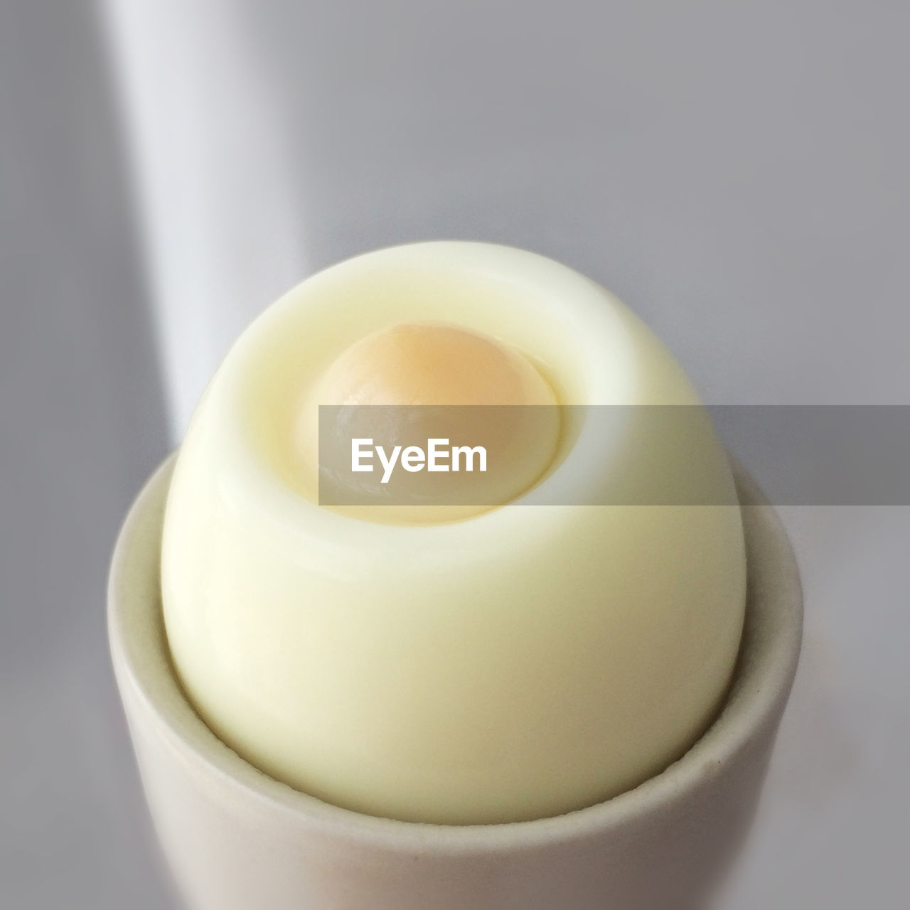 Close-up of egg in cup against gray background