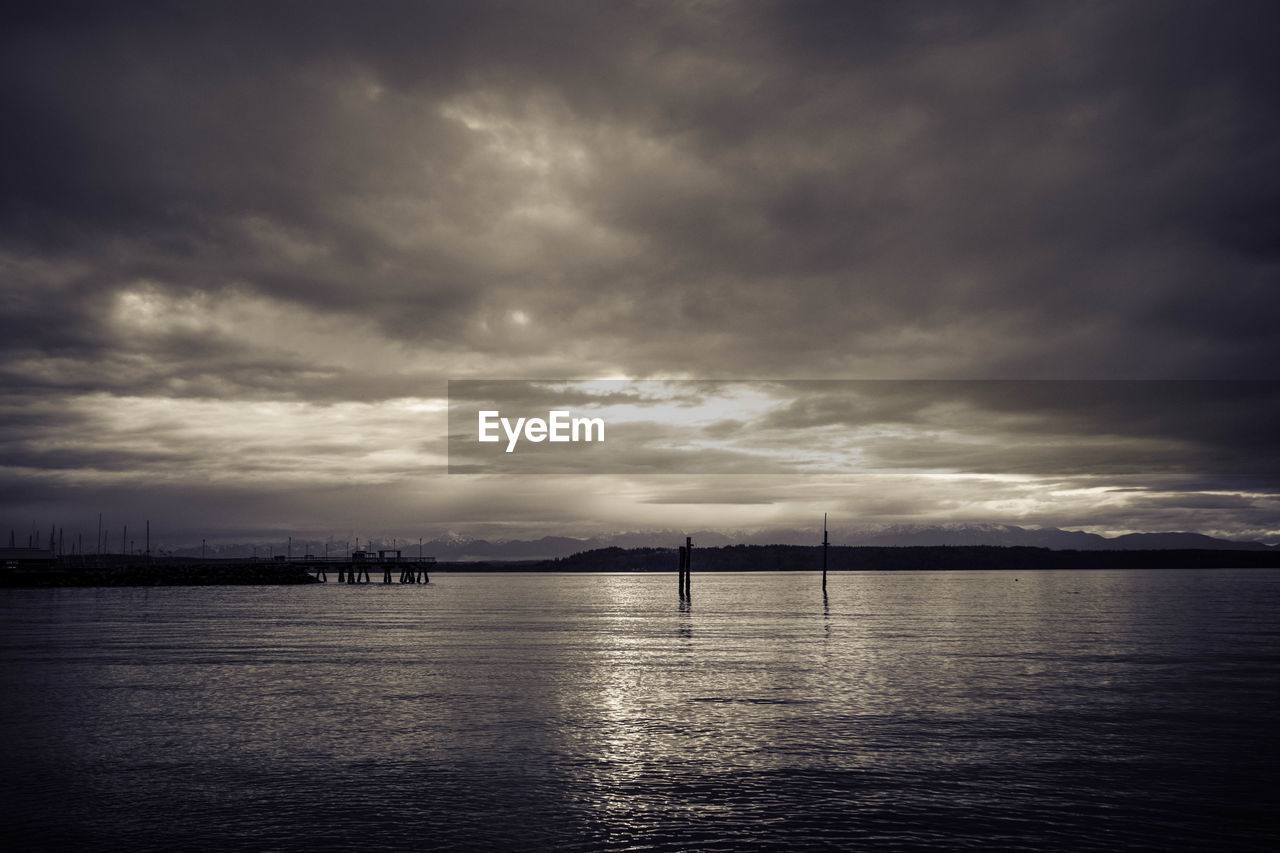 Scenic view of calm sea against cloudy sky