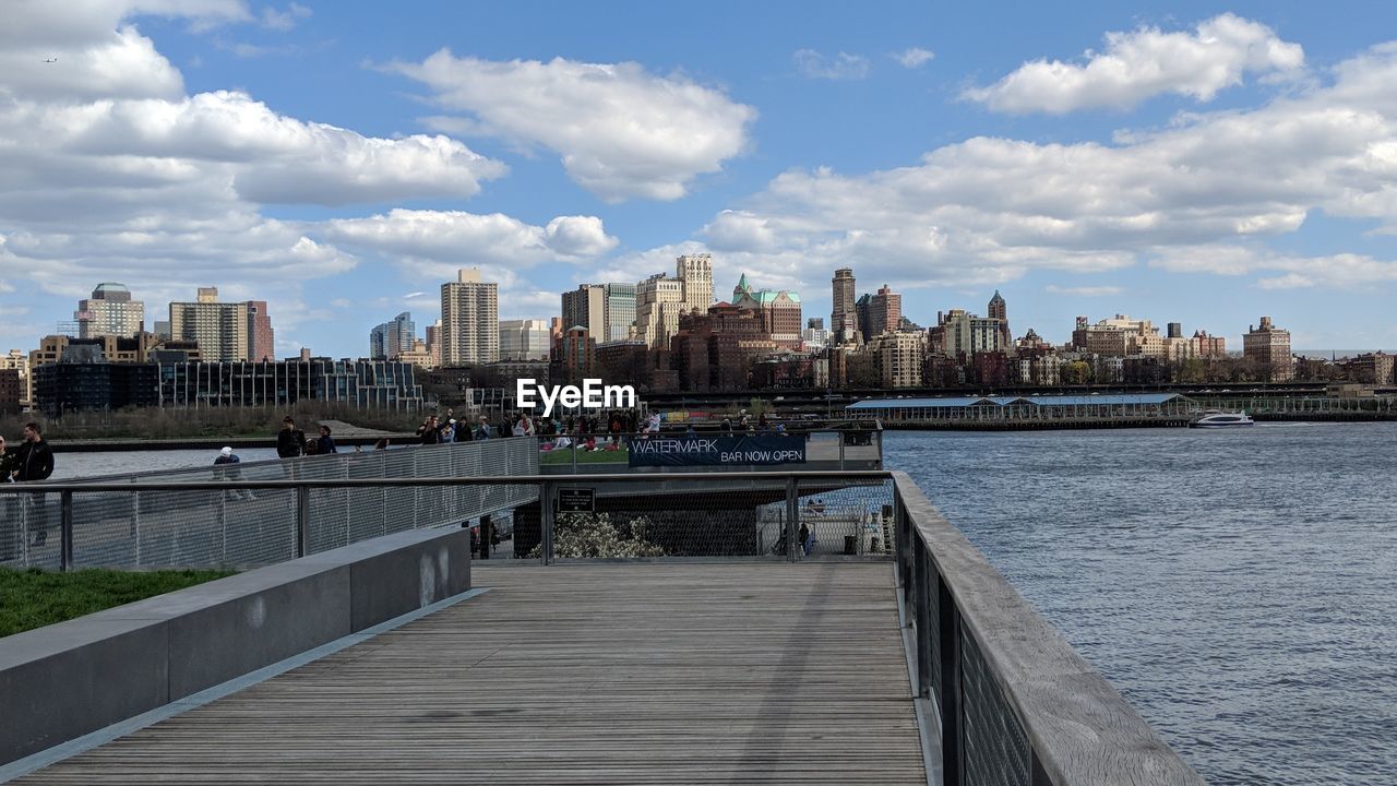 BRIDGE OVER RIVER AGAINST BUILDINGS IN CITY