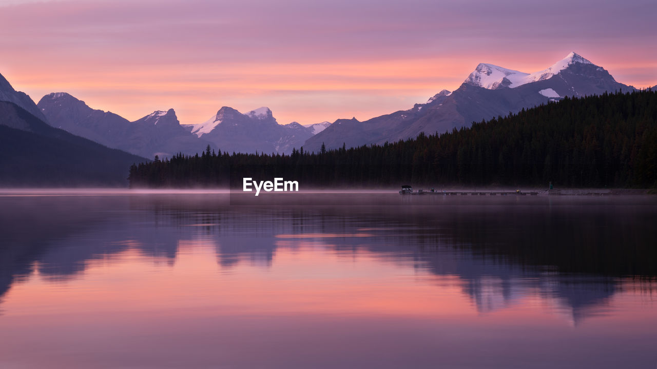 Scenic view of lake and mountains against sky during sunset