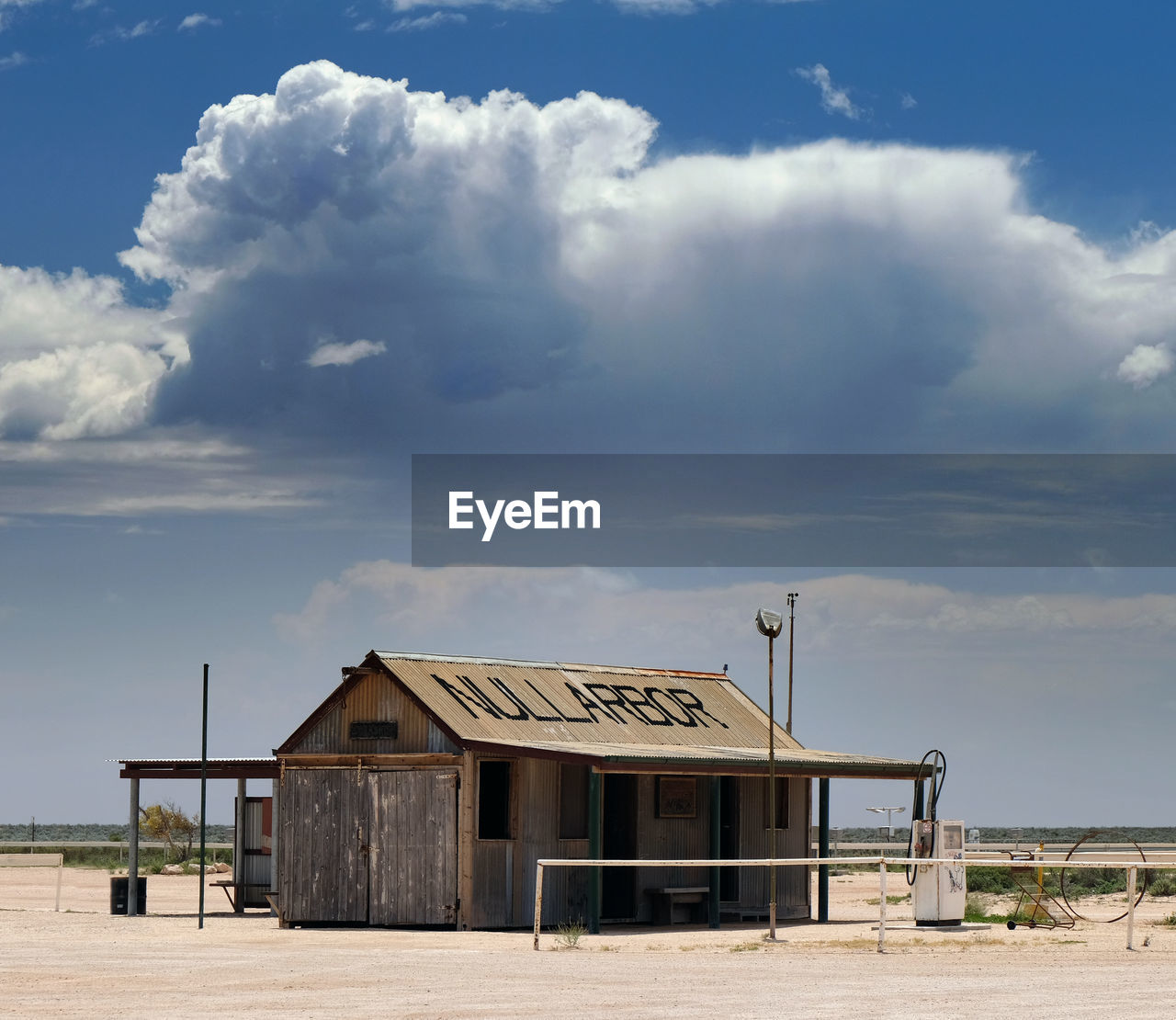 HOUSE ON BEACH BY BUILDING AGAINST SKY