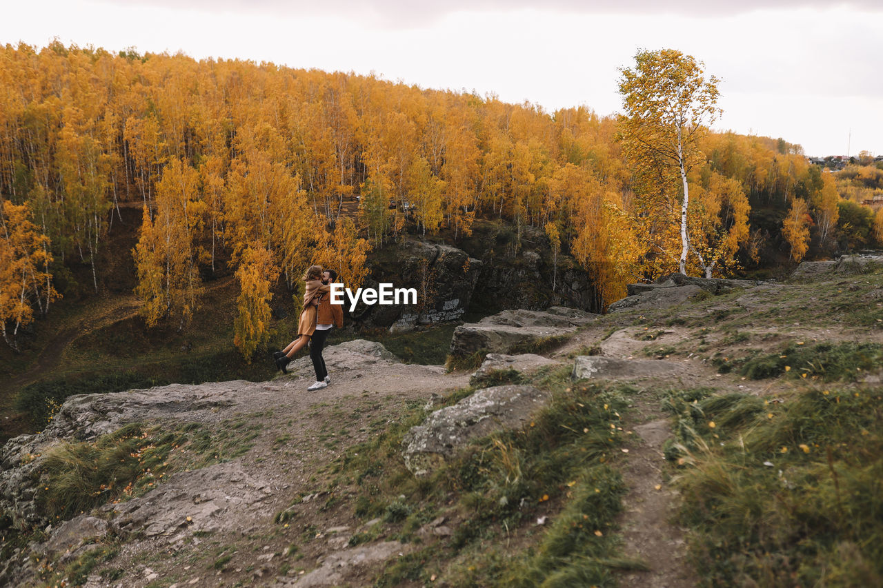 Happy people in love are travel hike in nature in the autumn forest. romantic trip to countryside