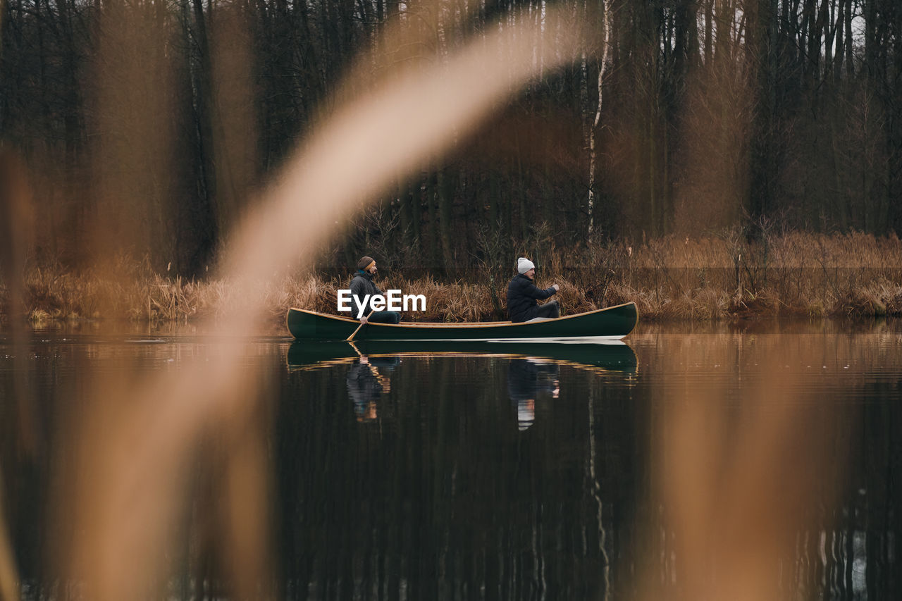 Smiling men boating in lake