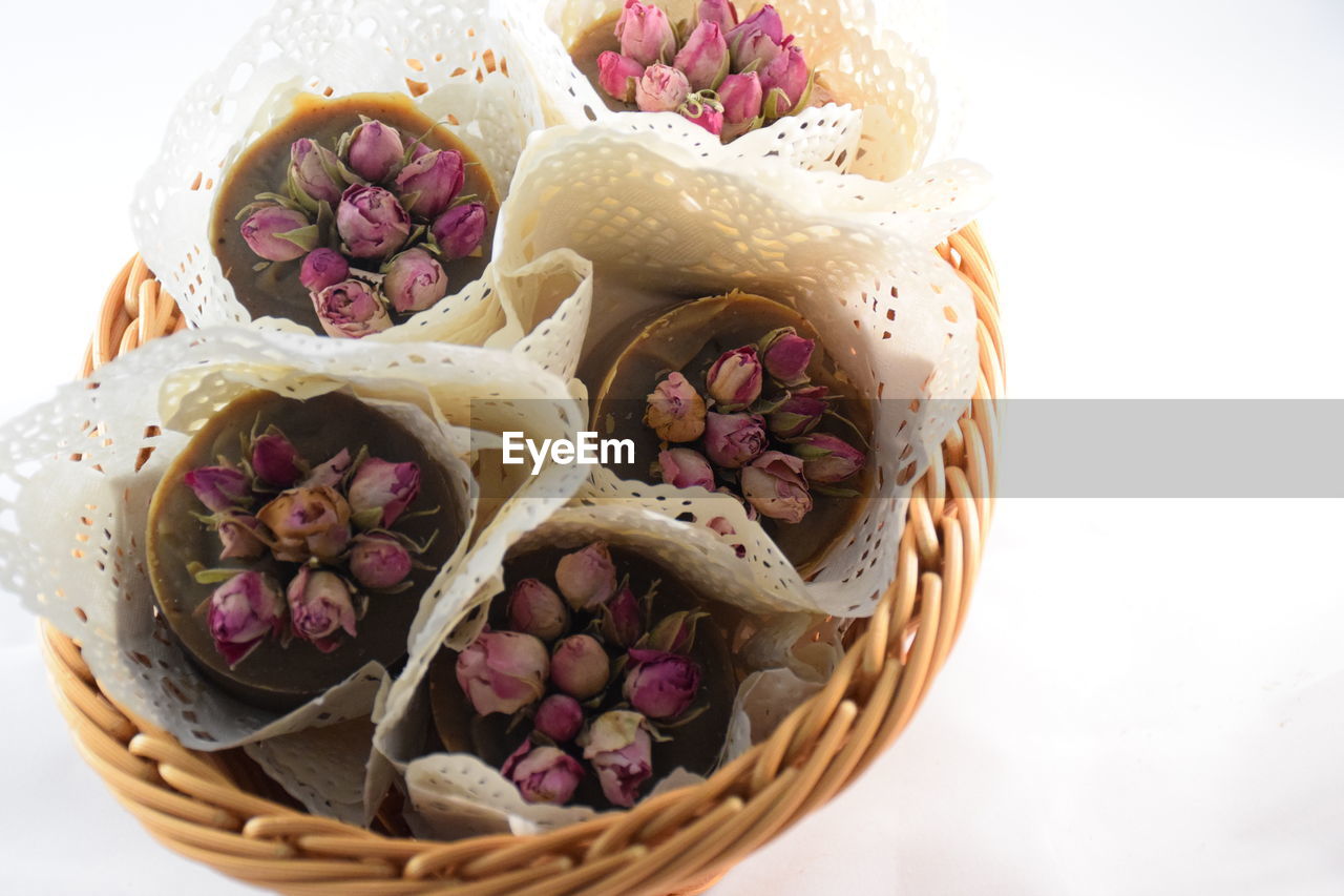 High angle view of pink flowers in basket against white background