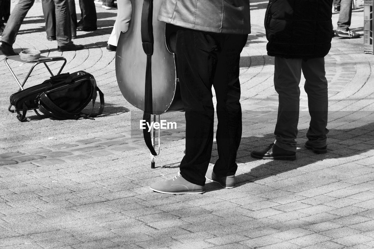 Low section of performer standing with musical instrument on street