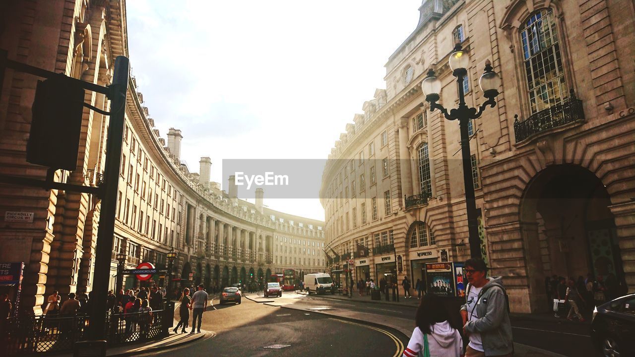 PEOPLE ON CITY STREET AMIDST BUILDINGS