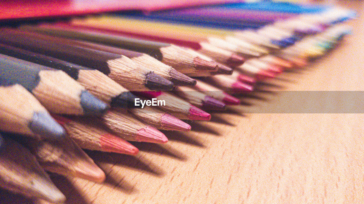 pencil, colored pencil, multi colored, writing instrument, close-up, large group of objects, variation, still life, no people, indoors, in a row, office supplies, wood, craft, arrangement, pink, high angle view, sharp, creativity, table, order, selective focus, side by side, abundance, focus on foreground