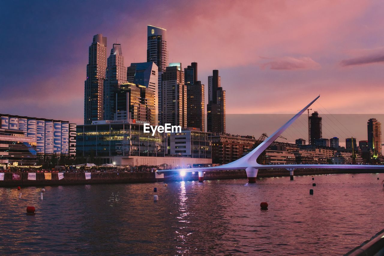 bridge over river in city at sunset