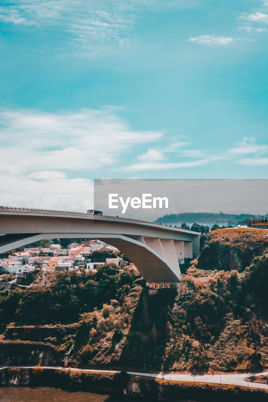 ARCH BRIDGE OVER RIVER BY BUILDINGS AGAINST SKY