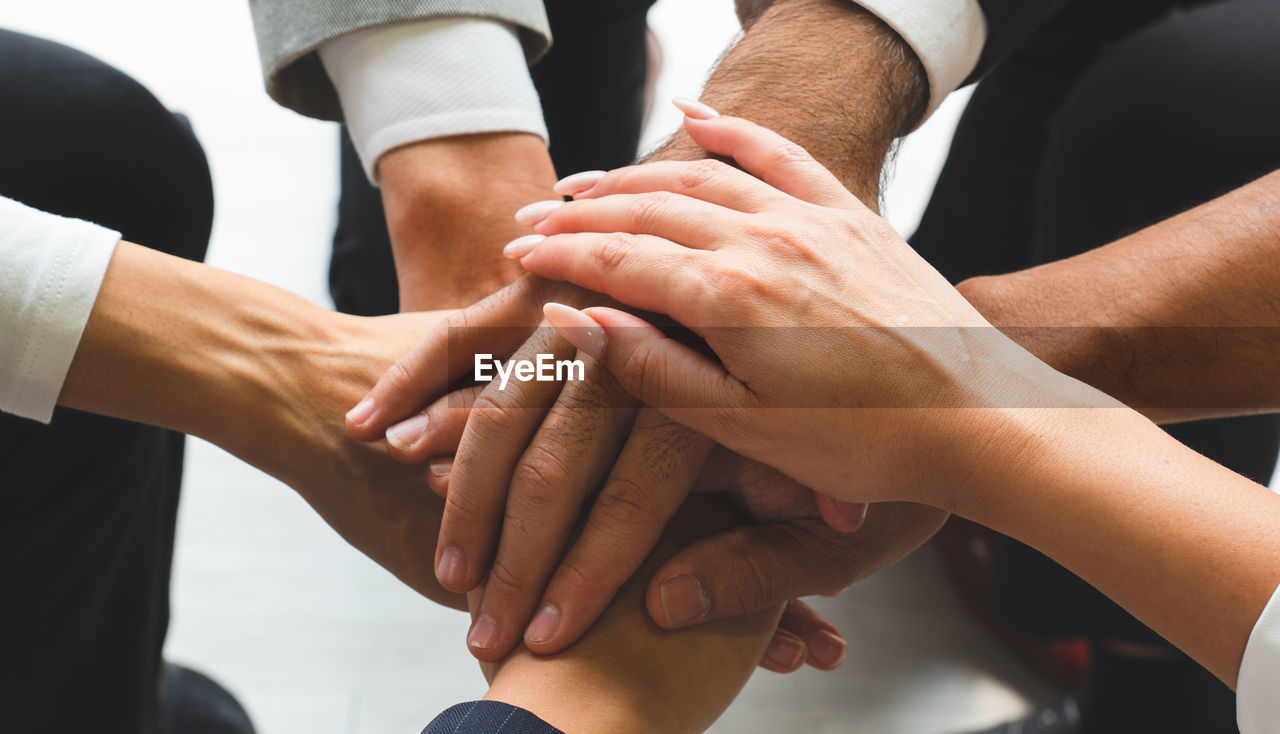 Cropped hands of business people stacking hands