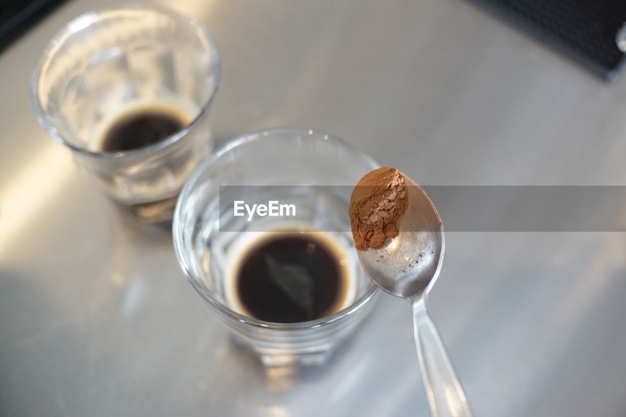 HIGH ANGLE VIEW OF COFFEE ON GLASS TABLE