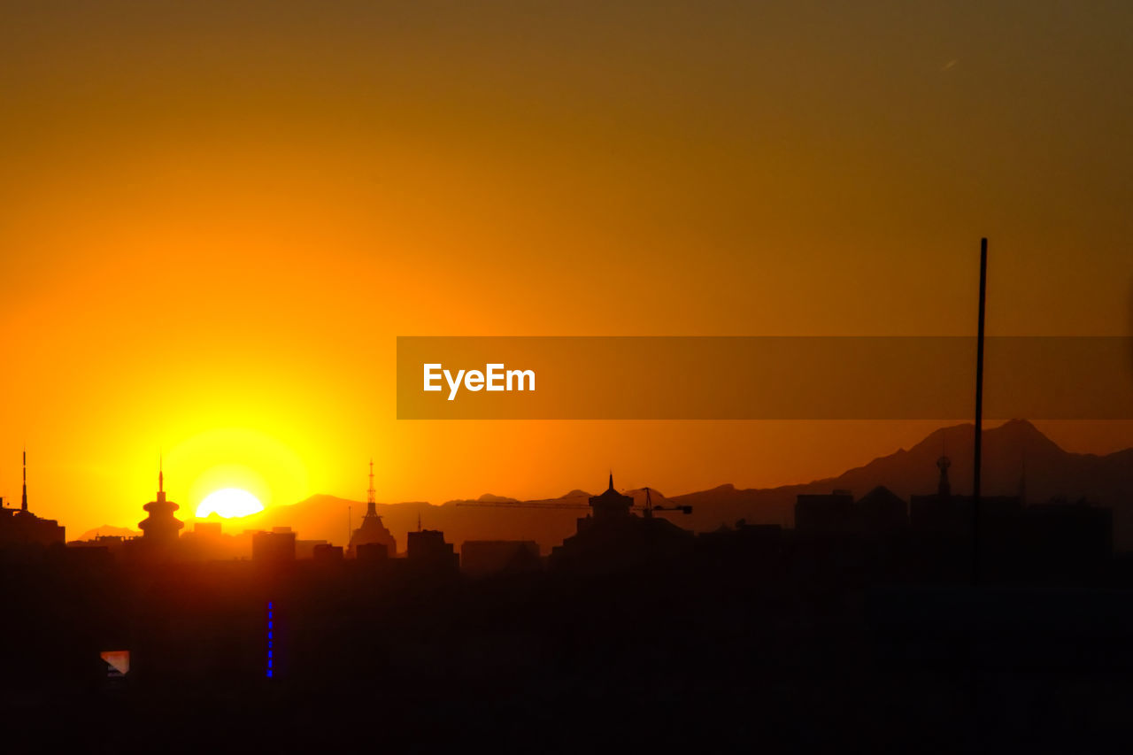 Silhouette cityscape against sky during sunset