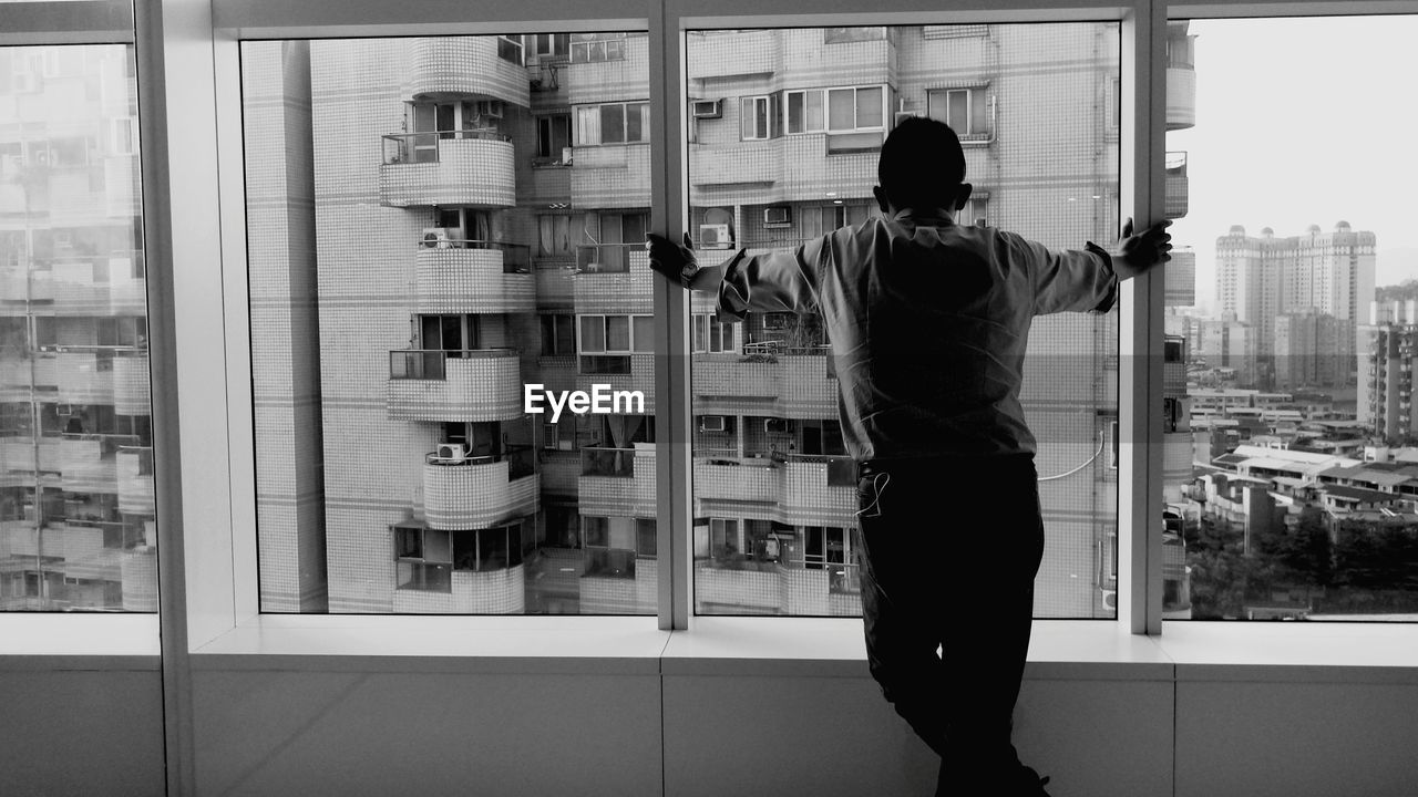 Man standing against window