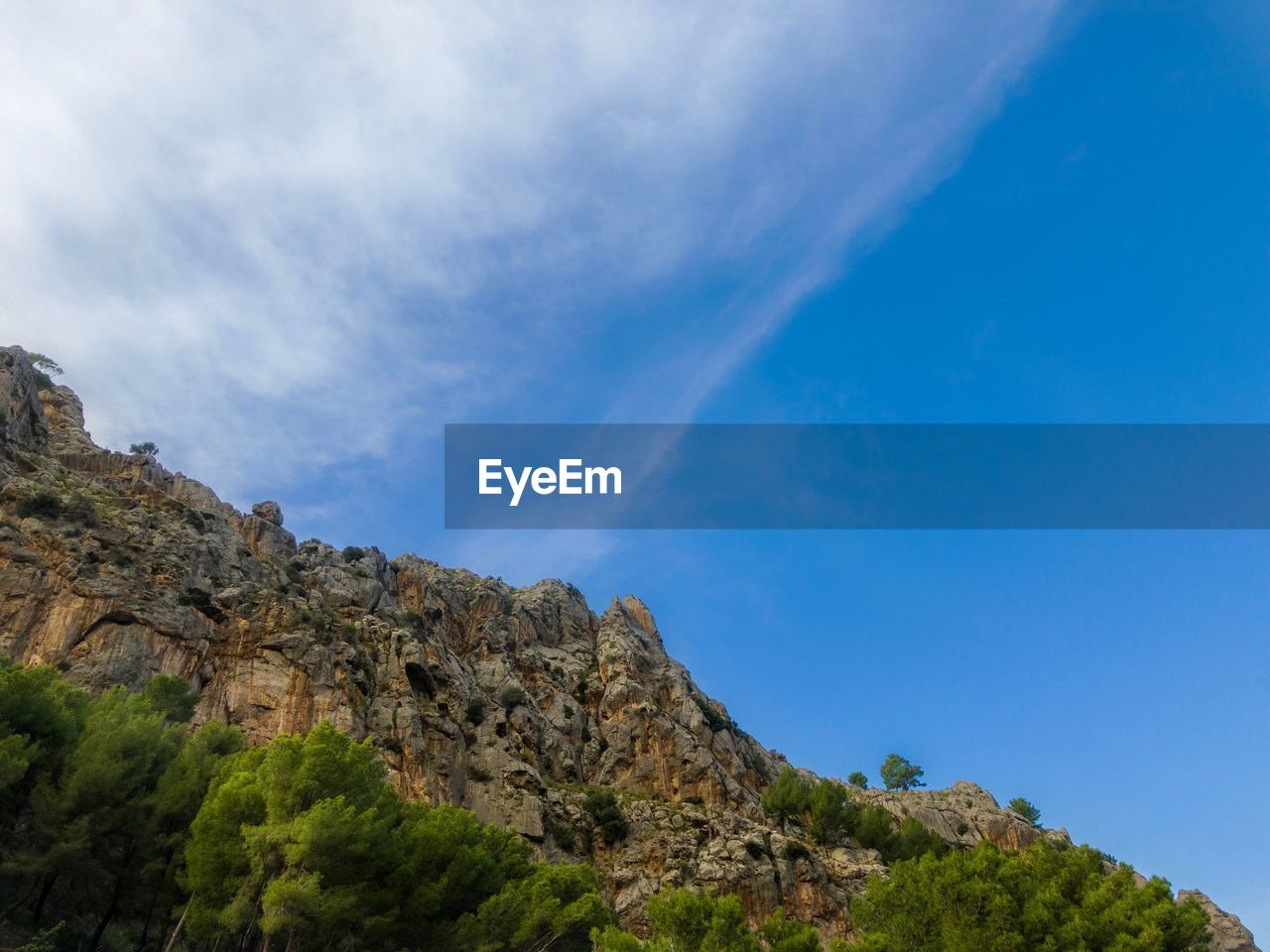 Low angle view of mountain against blue sky