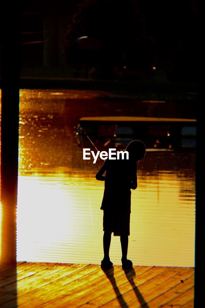 FULL LENGTH OF BOY STANDING IN ILLUMINATED LIGHT