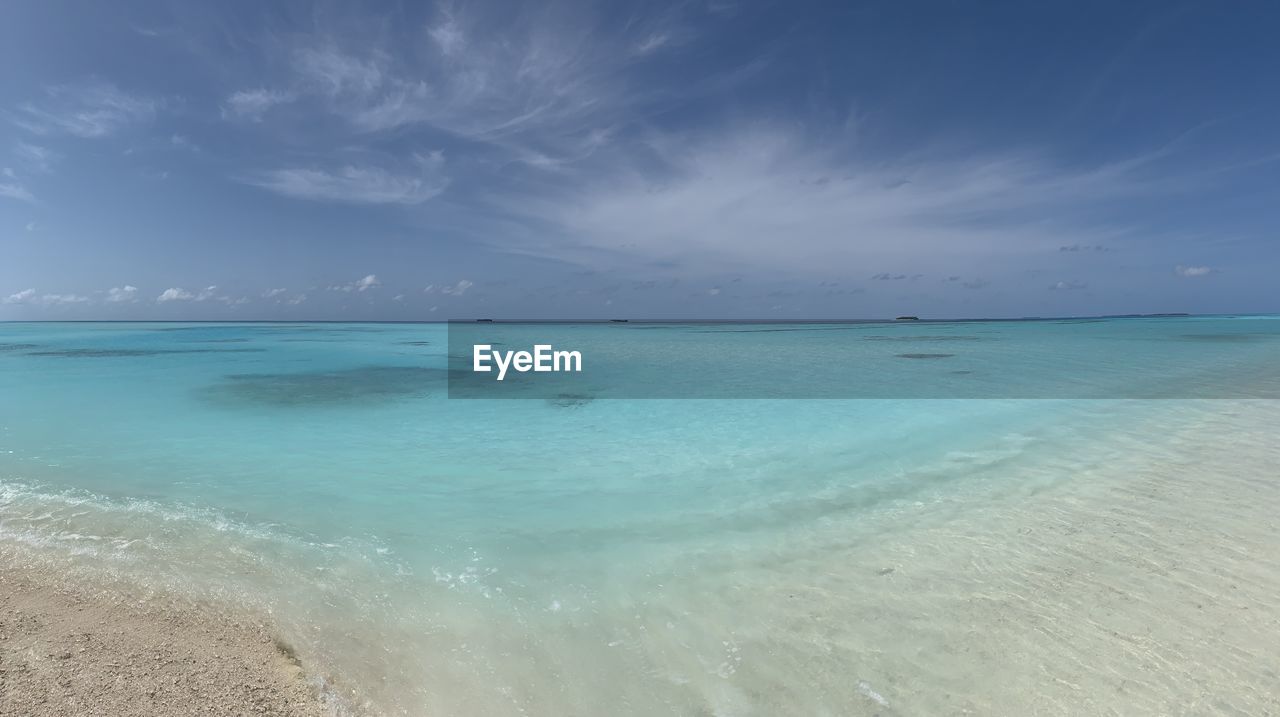 SCENIC VIEW OF BEACH AGAINST BLUE SKY