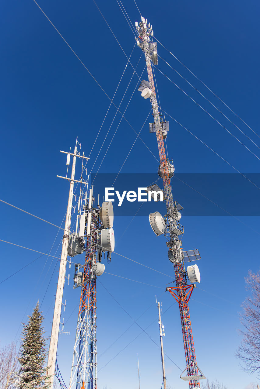 LOW ANGLE VIEW OF ELECTRICITY PYLON AGAINST BLUE SKY