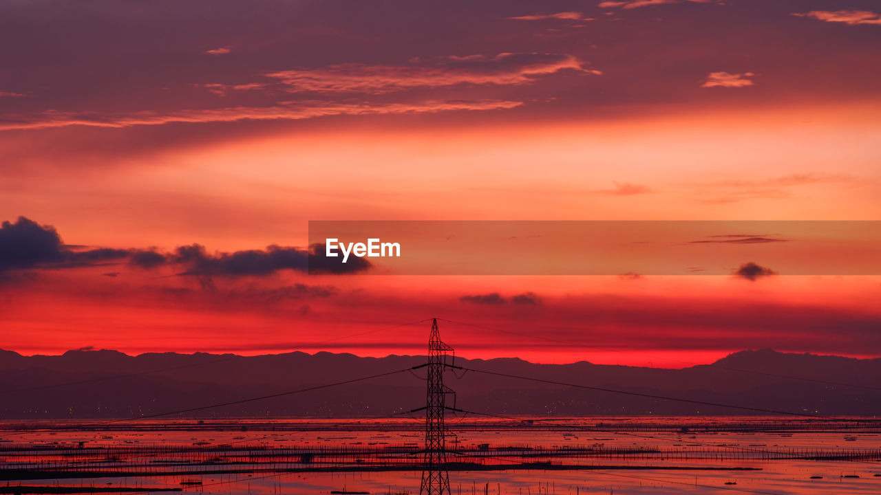 Silhouette mountain against dramatic sky during sunrise