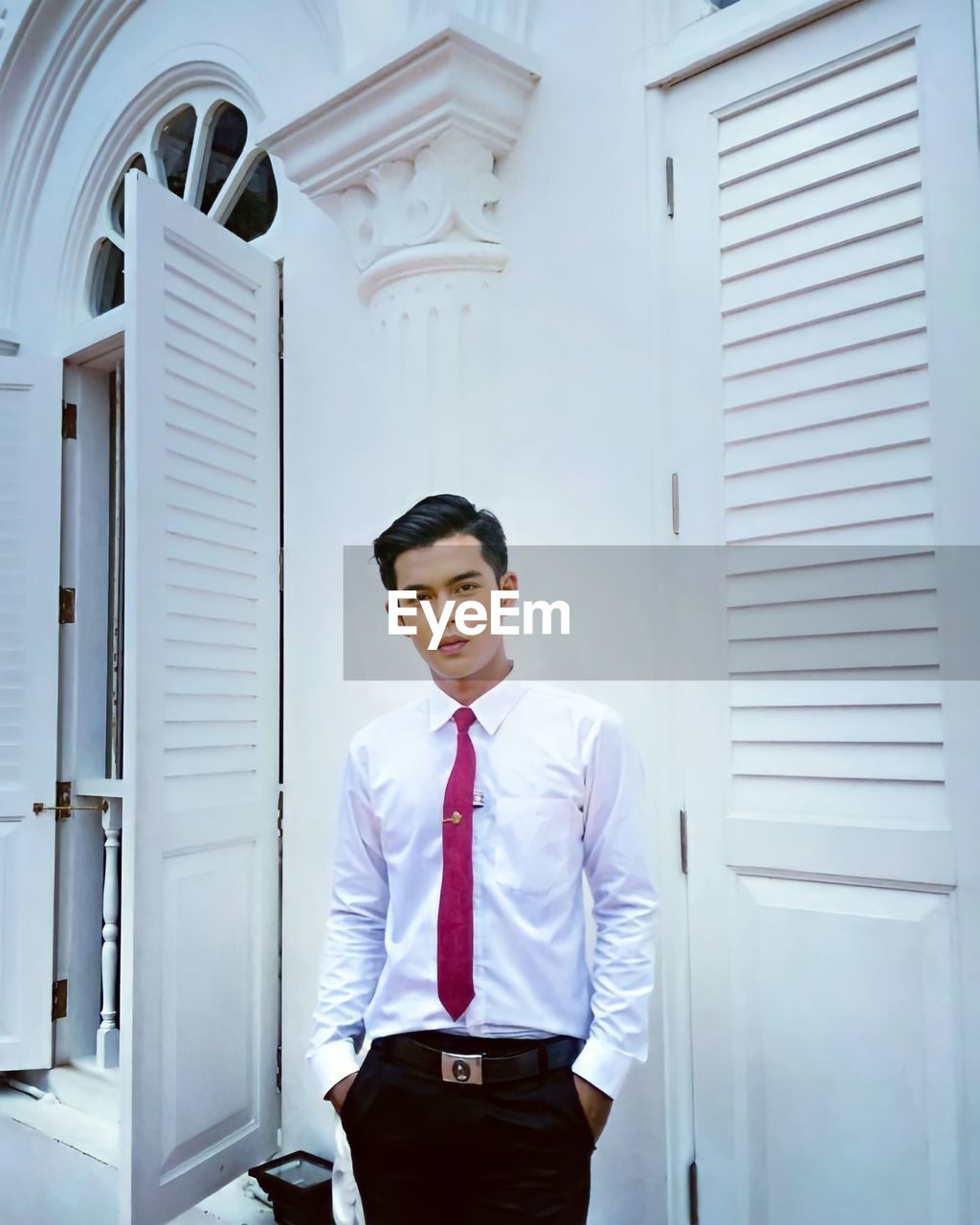 Portrait of businessman standing against wall