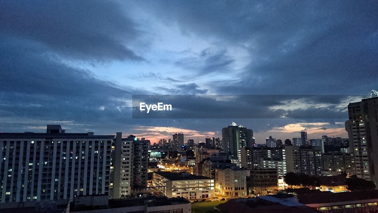 VIEW OF ILLUMINATED CITYSCAPE AGAINST SKY