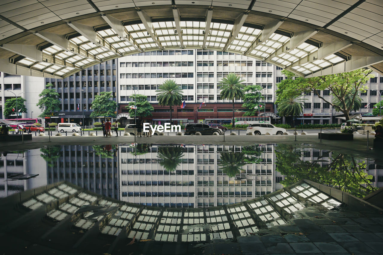 Reflection of arch on puddle in city