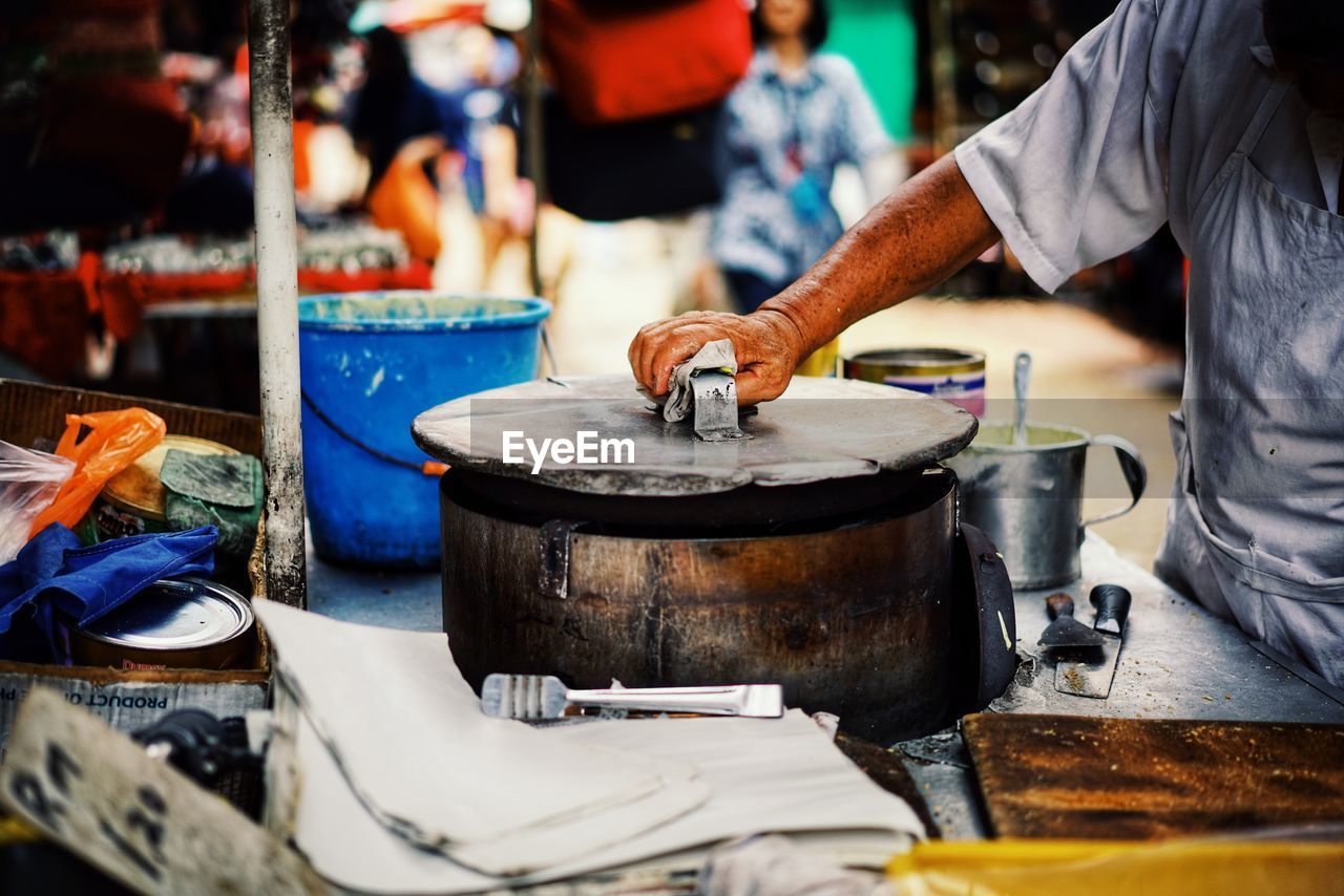 Midsection of man preparing food at market stall