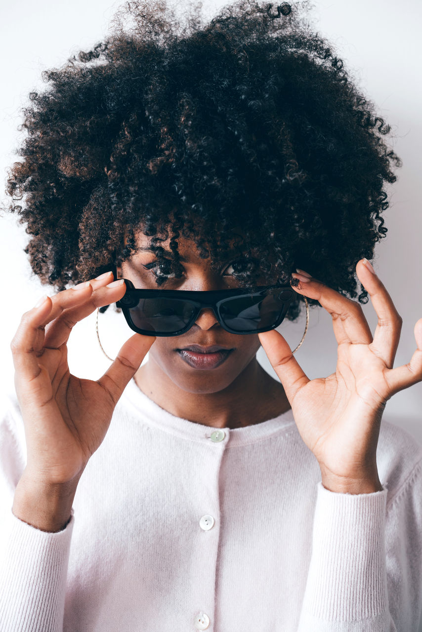 Beautiful black woman with afro hair wearing futuristic video recording glasses
