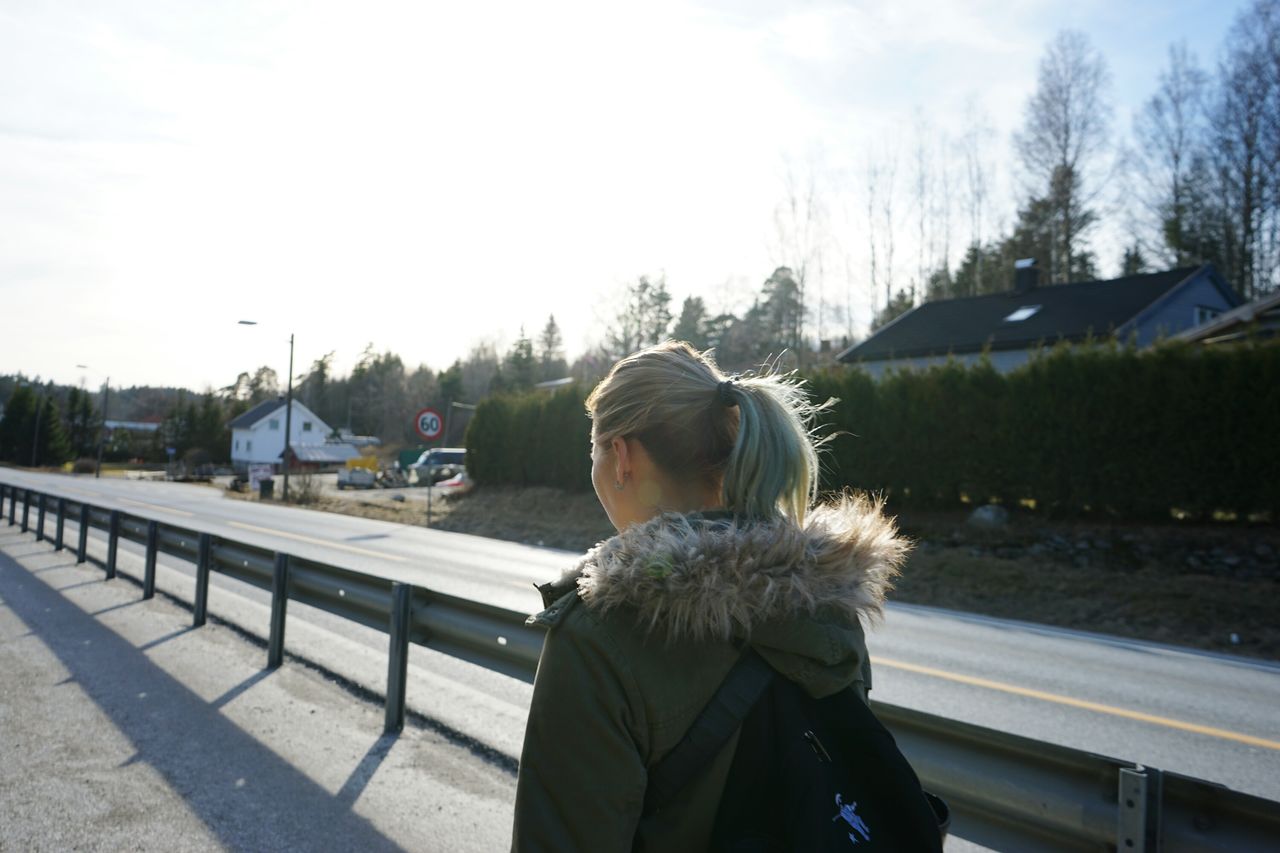 Rear view of woman walking on road