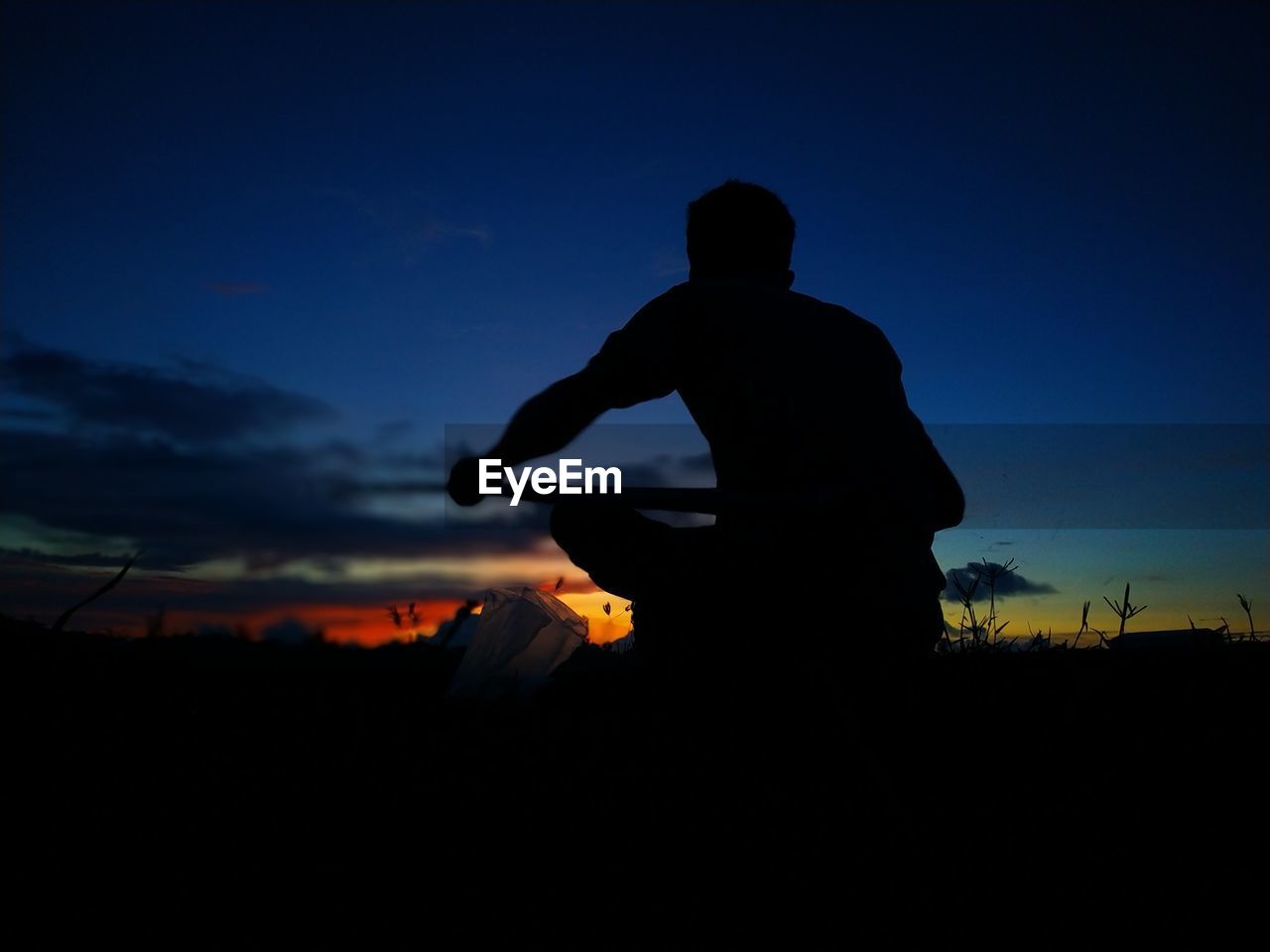 SILHOUETTE MAN STANDING ON FIELD DURING SUNSET