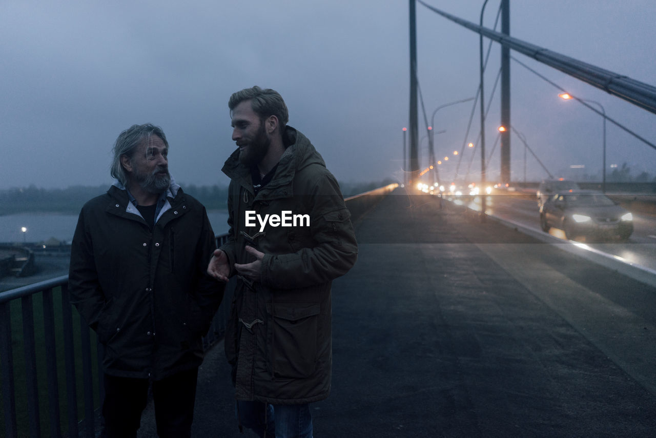 Father and son meeting on bridge, discussing business