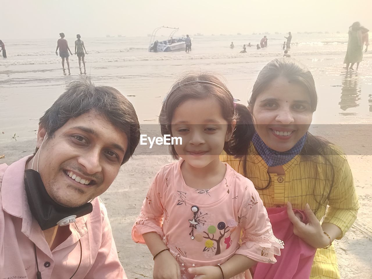 PORTRAIT OF SMILING FRIENDS ON BEACH