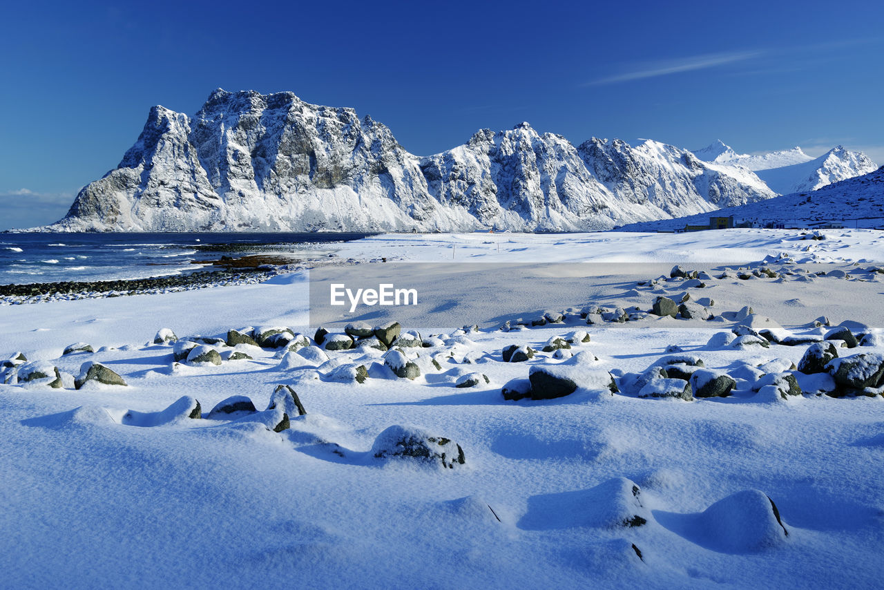 Scenic view of snowcapped mountains against blue sky