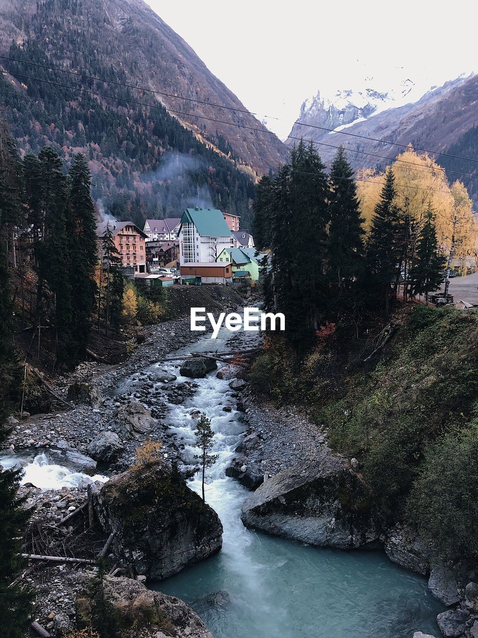 Scenic view of lake amidst trees and buildings against sky