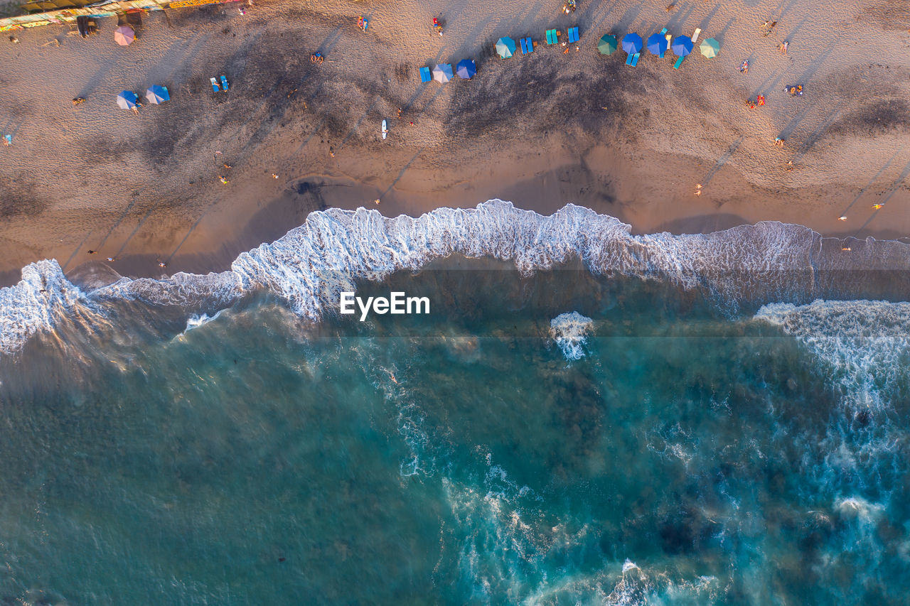 Aerial view of people enjoying on beach against sea