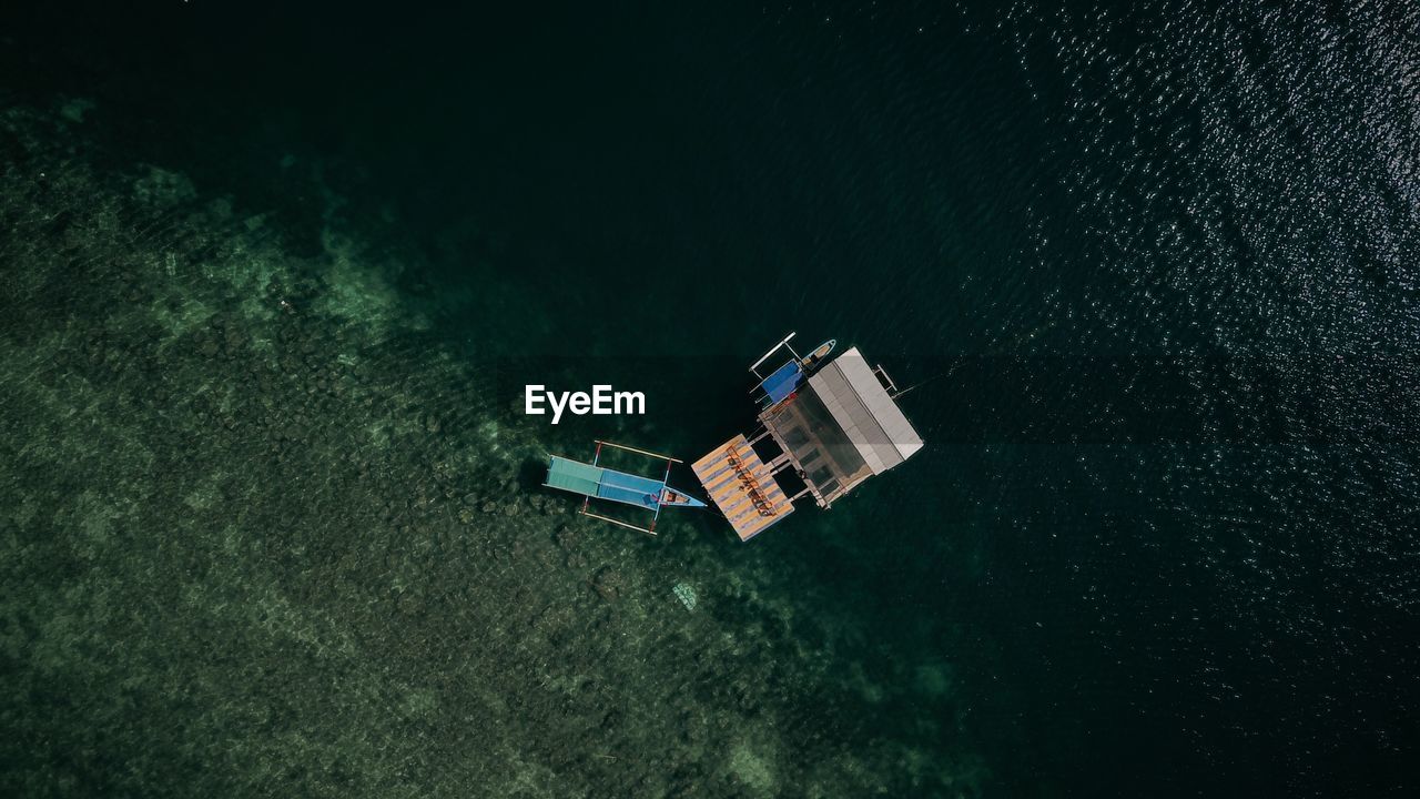 Aerial view of built structure and boat floating on sea