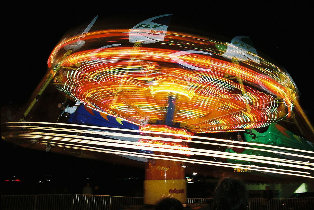 LOW ANGLE VIEW OF ILLUMINATED FERRIS WHEEL AT NIGHT