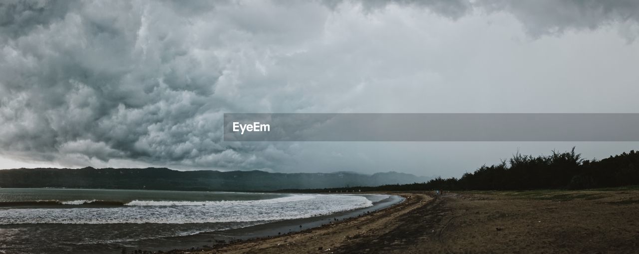 Panoramic view of beach and sea against cloudy sky