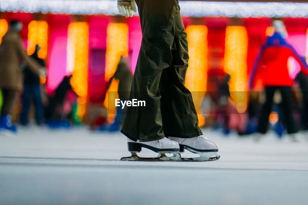 Low section of person ice-skating at night