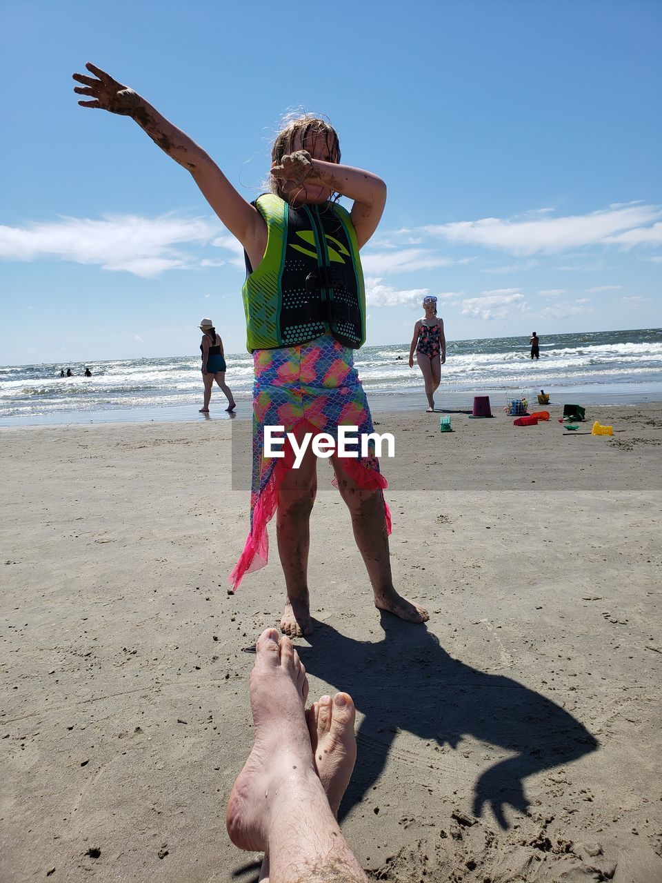 PEOPLE ON BEACH AGAINST SEA