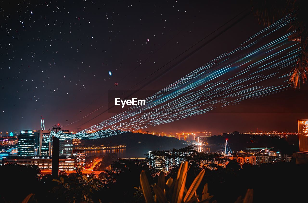 Illuminated cityscape against sky at night