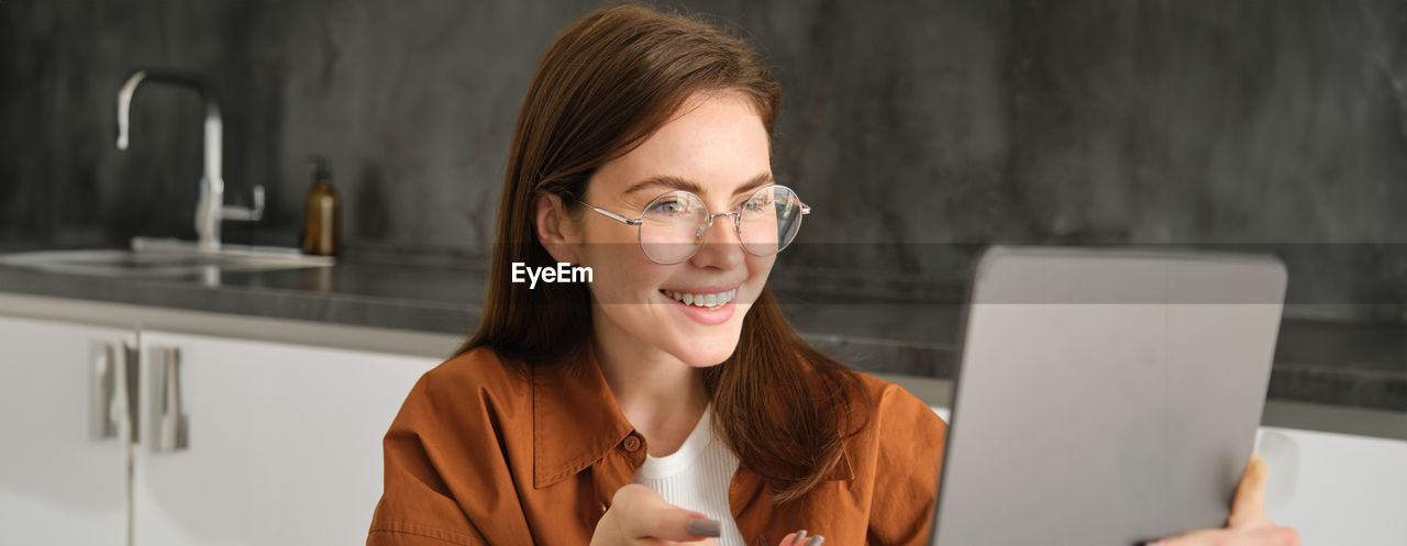 young woman using laptop while sitting at home